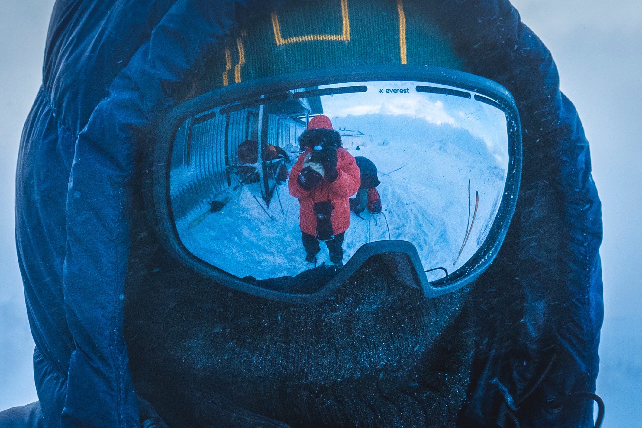 Person med skidmask och skidglasögon i vinterkyla under fjälltur.
Person wearing ski goggles and face mask in extreme winter conditions, mountain expedition. fjällkloka äventyr